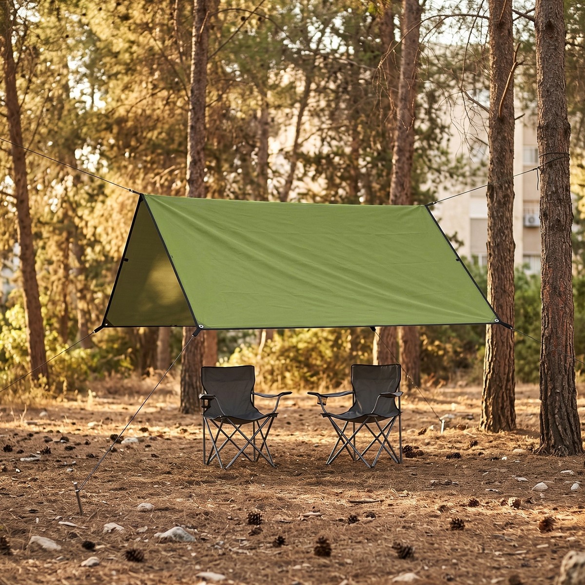 יריעת צל VELA 210 מתוחה בין עצים מעל כיסאות קמפינג ביער